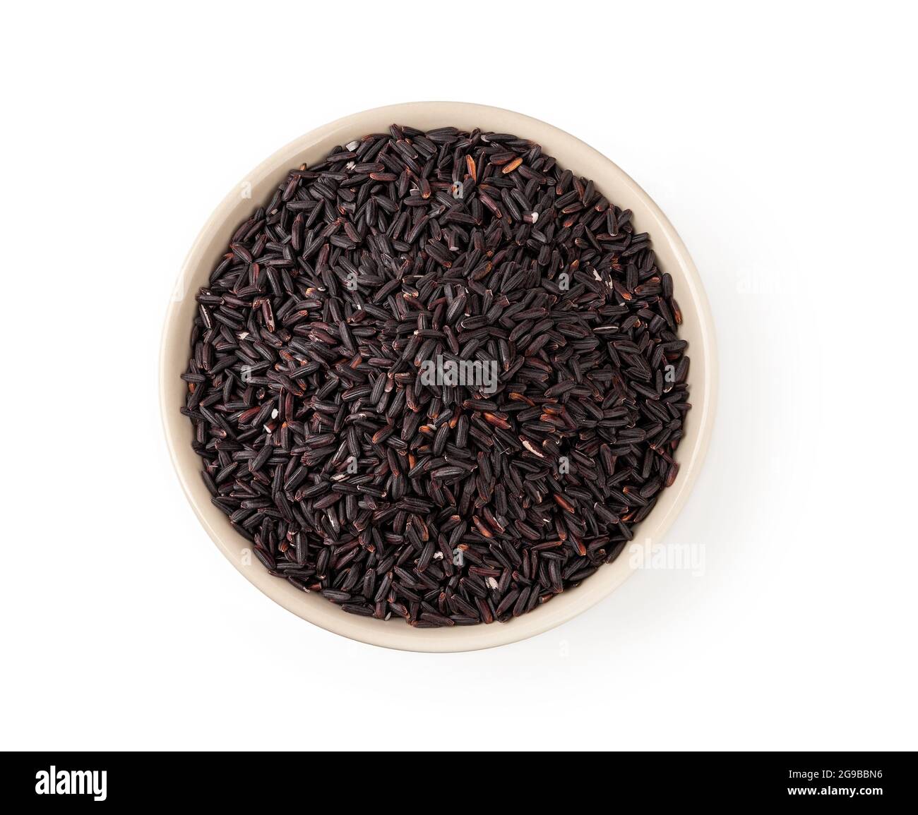 Riso nero crudo in una ciotola di ceramica beige isolata su sfondo bianco. Riso nero organico non lucidato come fonte di carboidrati complessi. Vista dall'alto. Foto Stock