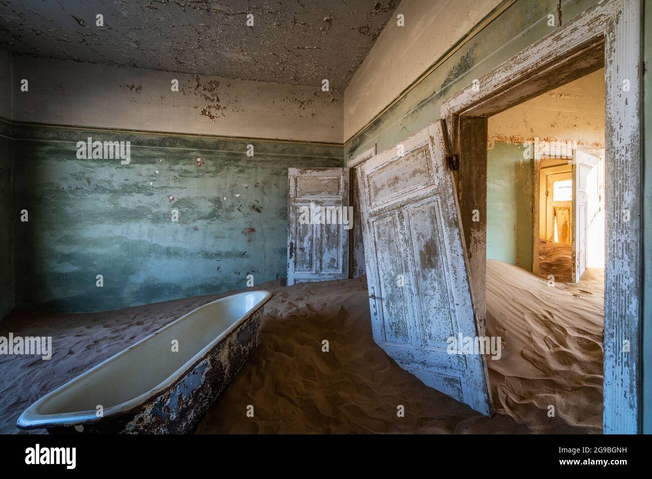 L'edificio abbandonato è stato ripreso dalla sabbia incrollabile nella città fantasma di Kolmanskop vicino a Luderitz, nel deserto del Namib, in Namibia. Foto Stock