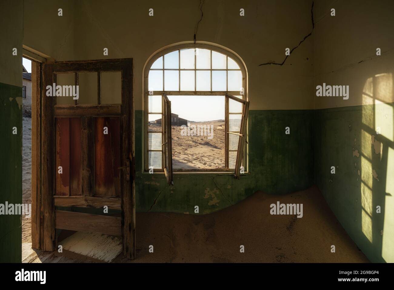 L'edificio abbandonato è stato ripreso dalla sabbia incrollabile nella città fantasma di Kolmanskop vicino a Luderitz, nel deserto del Namib, in Namibia. Foto Stock