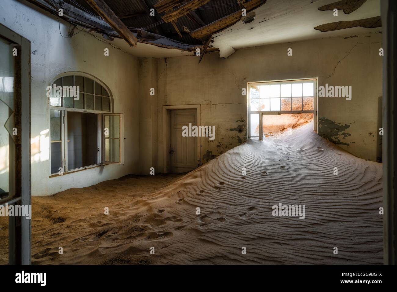 L'edificio abbandonato è stato preso in consegna dalla sabbia incrostante nella vecchia città mineraria di diamanti di Kolmanskop vicino a Luderitz, Namib Desert, Namibia. Foto Stock