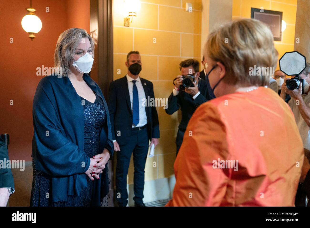 Bayreuth, Germania. 25 luglio 2021. Apertura del Richard Wagner Festival 2021 con una nuova produzione dell'opera "The Flying Dutchman". Katharina Wagner (l), direttore del Bayreuth Festival, dà il benvenuto alla cancelliera tedesca Angela Merkel (CDU) presso la Festspielhaus sulla Grüner Hügel. Credit: Nicolas Armer/dpa/Alamy Live News Foto Stock