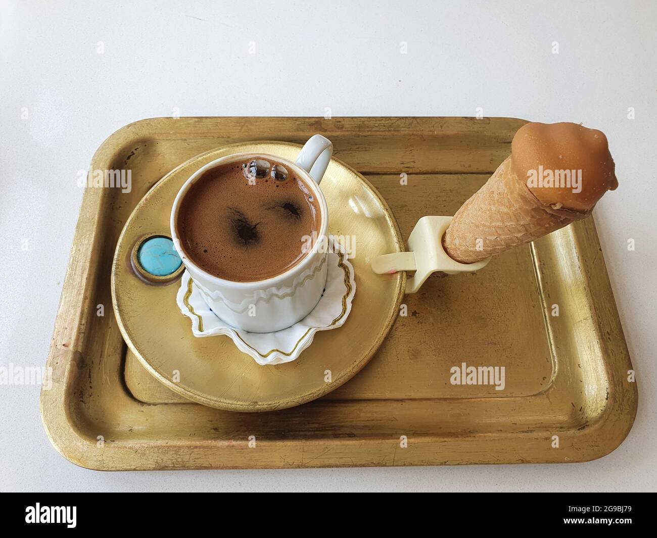 Delizioso caffè turco forte e aromatico. Servito con gelato su un vassoio di ottone Foto Stock
