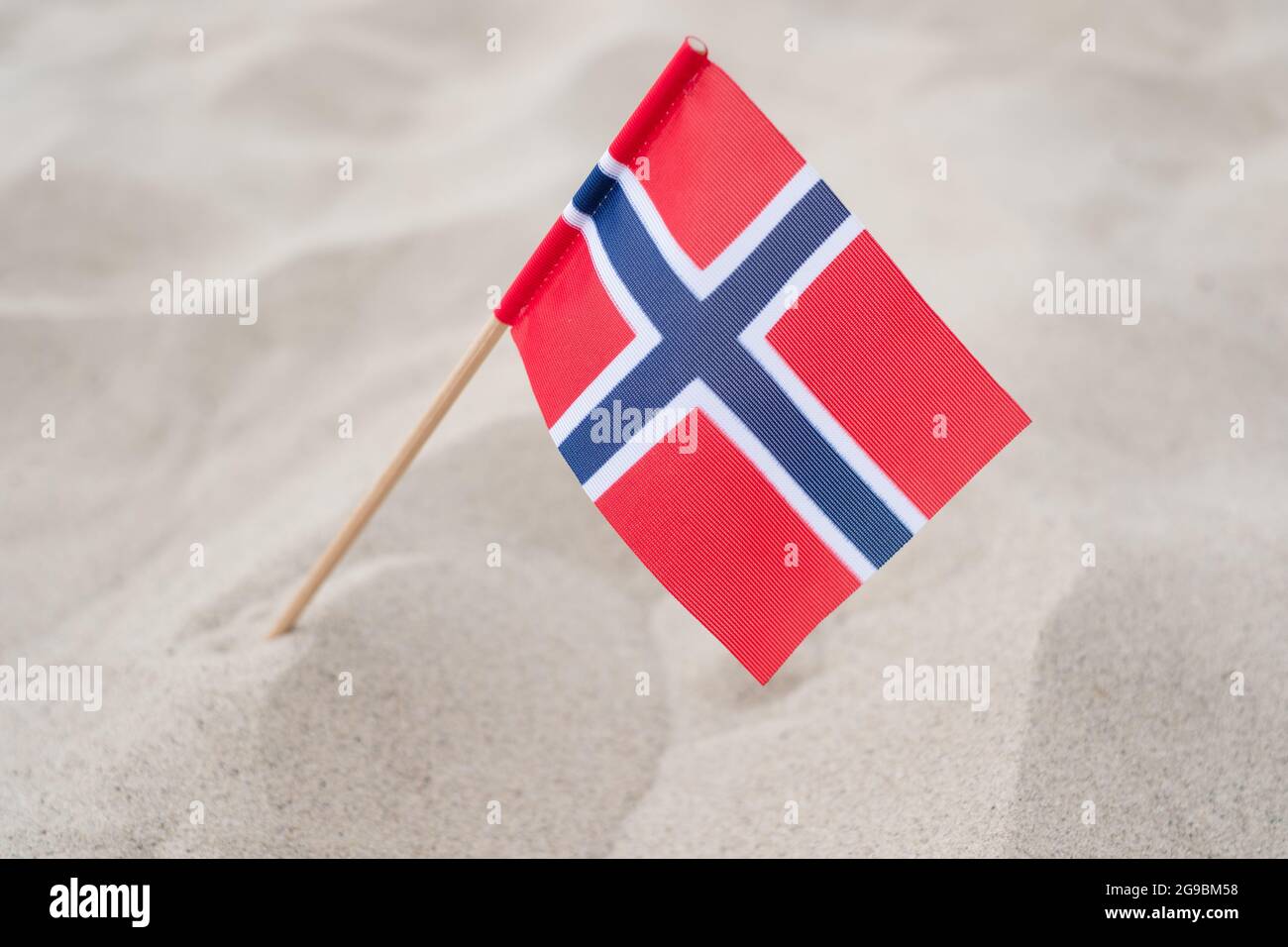 Bandiera della Norvegia su fondo sabbioso. Bandiera norvegese sventolando nel vento sulla spiaggia estiva Foto Stock