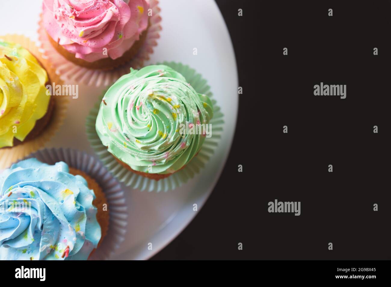 cupcakes colorati su sfondo nero Foto Stock