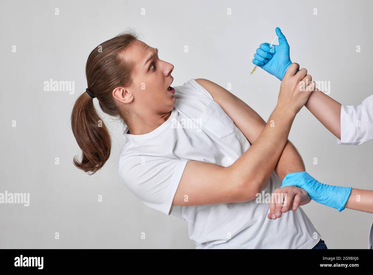 Paura dell'uomo durante la vaccinazione con coronavirus, immunizzazione con covid-19. Foto Stock