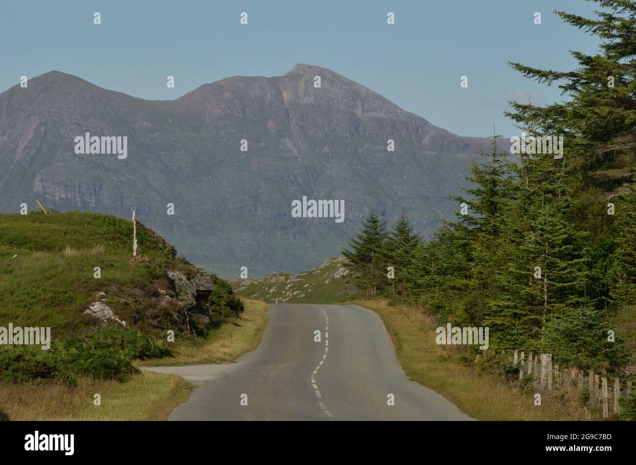 La A837, una strada di contea più tortuosa appena fuori Lochinver nelle Highlands scozzesi, Regno Unito. La montagna dietro è Quinag. Foto Stock