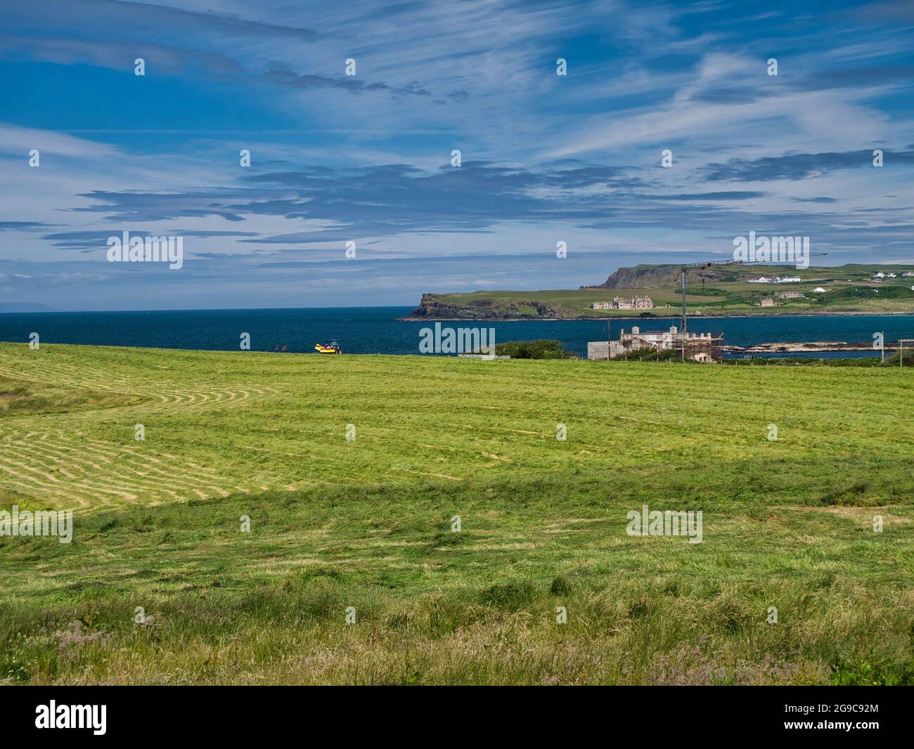 Un campo di erba tagliata per insilato sulla costa dell'Irlanda del Nord di Antrim Causeway. In una giornata di sole con cielo blu. Foto Stock
