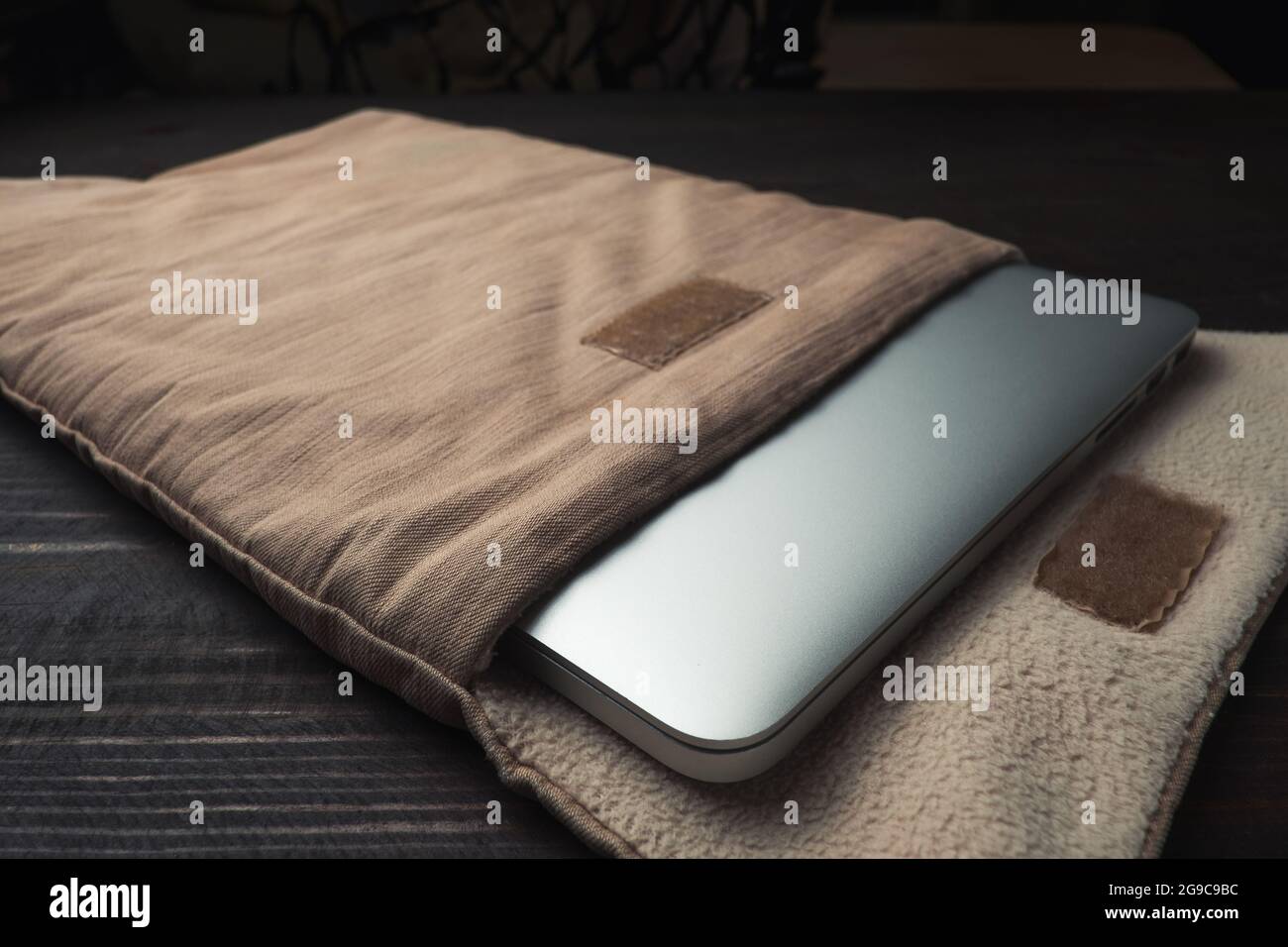 Laptop in una morbida custodia in tessuto, sul tavolo di legno Foto Stock