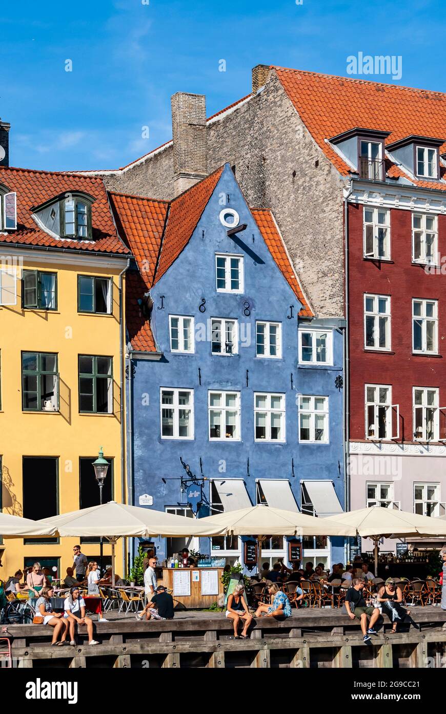 Dettaglio del molo turistico di Nyhavn con persone che si rilassano, edifici colorati e barche nella città vecchia di Copenhagen, Danimarca Foto Stock