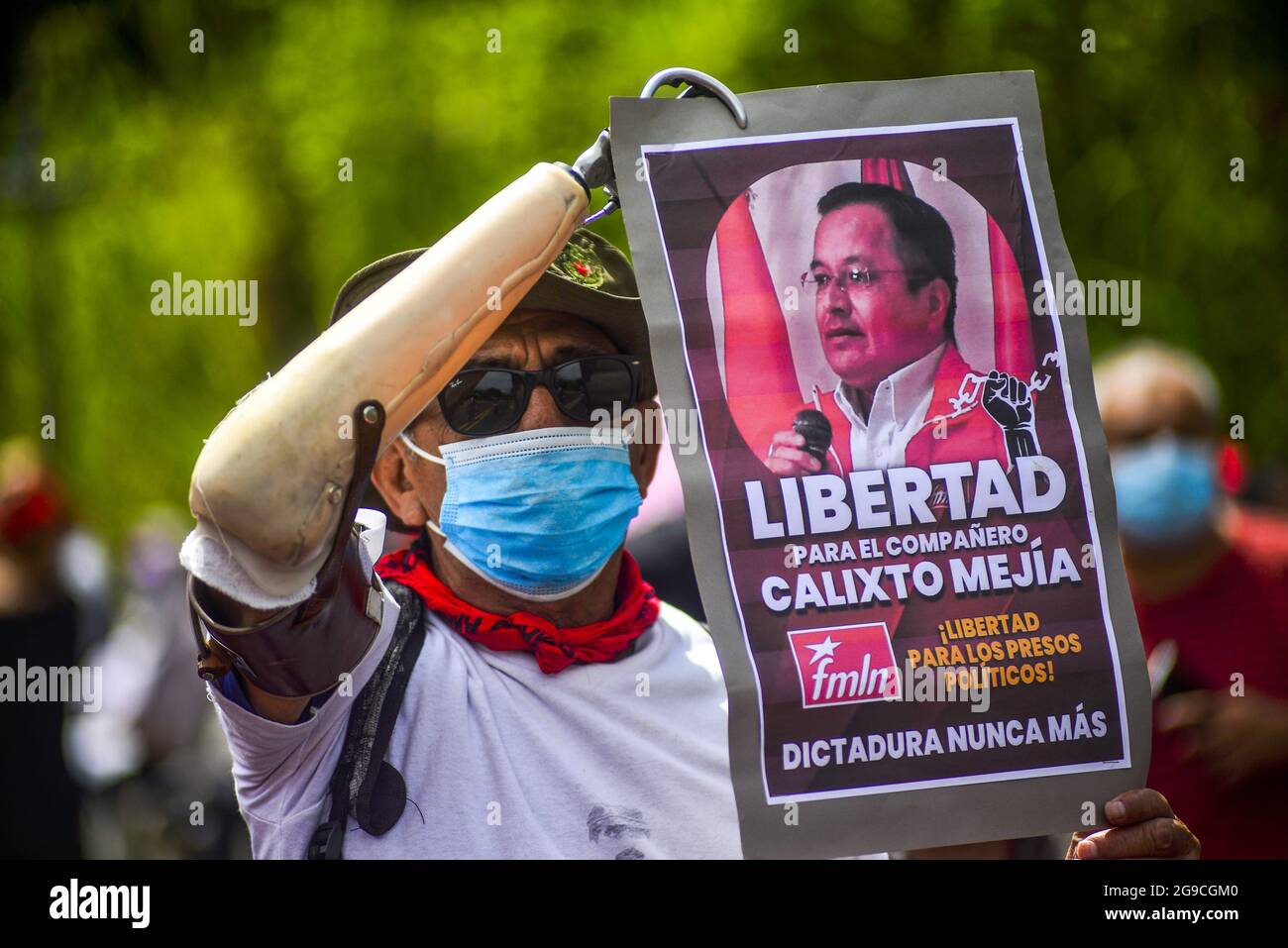 Un ex combattente guerriglia con un braccio protesico tiene un segno che chiede la liberazione di un membro FMLN durante la dimostrazione. Cinque ex funzionari del primo governo di sinistra FMLN (Frente Farabundo Martí para la Liberación Nacional) sono stati accusati di accuse di corruzione dall'ufficio del procuratore generale. I sostenitori della FMLN protestano ha detto che la decisione di chiamare questa prigione politica, in quanto l'attuale procuratore generale è stato imposto dal partito al governo dopo aver cacciato il procuratore costituzionale e cinque giudici superiori. Foto Stock