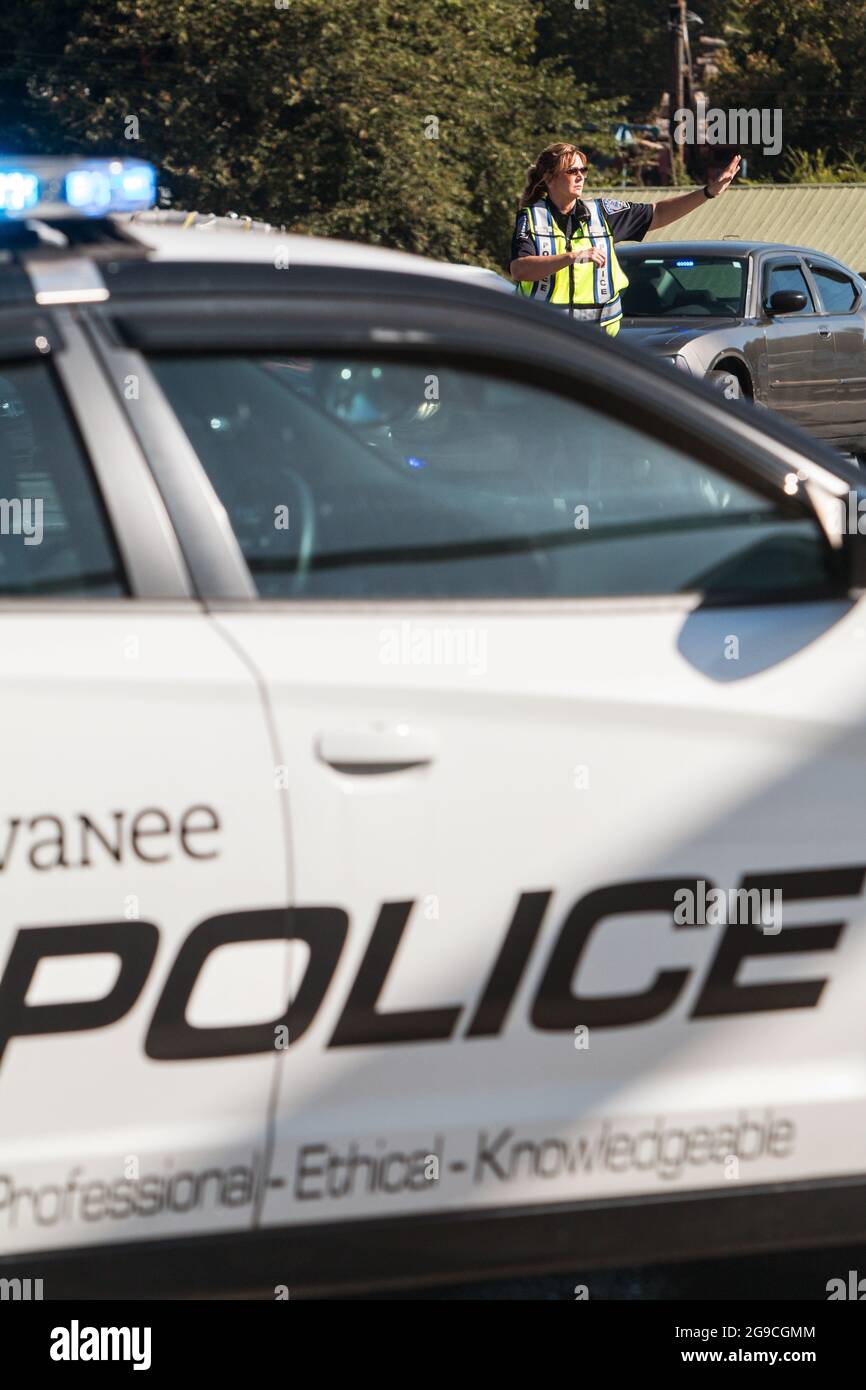 Suwanee, GA, USA - 21 settembre 2019: Un ufficiale di polizia femminile dirige il traffico veicolare al Suwanee Fest, un festival autunnale. Foto Stock