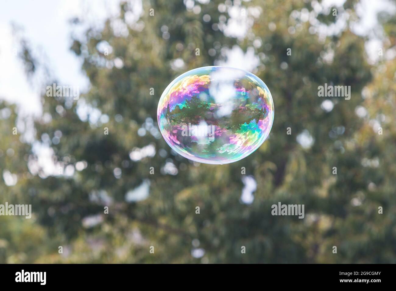 Una grande bolla di sapone galleggia attraverso l'aria in un festival. Foto Stock