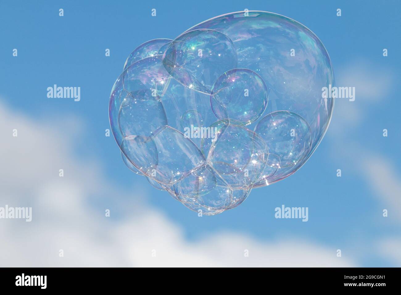 Una grande bolla fatta di acqua saponata galleggia attraverso la midair contro un cielo blu. Foto Stock