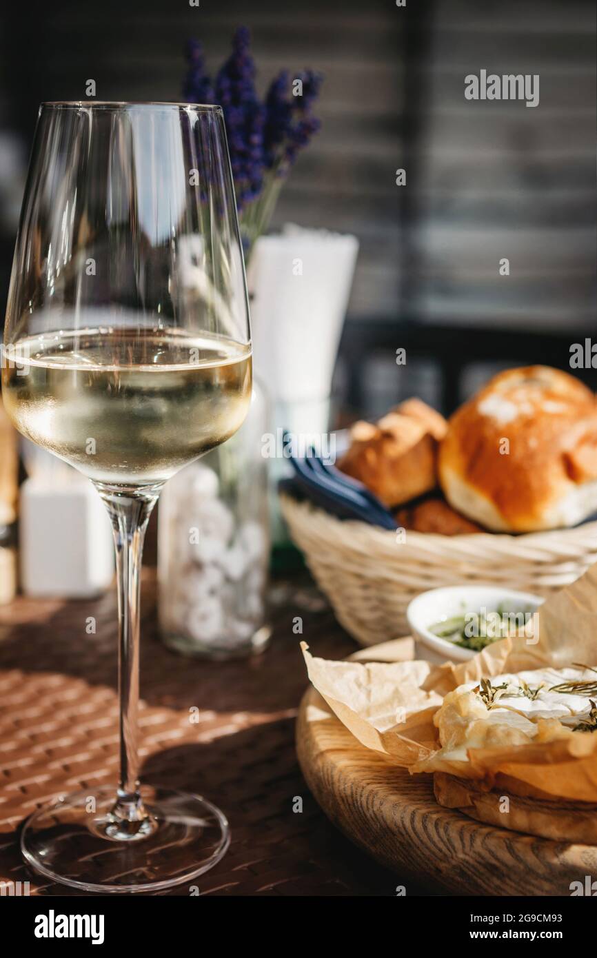 Bicchiere di vino bianco freddo e formaggio camembert al forno Foto Stock