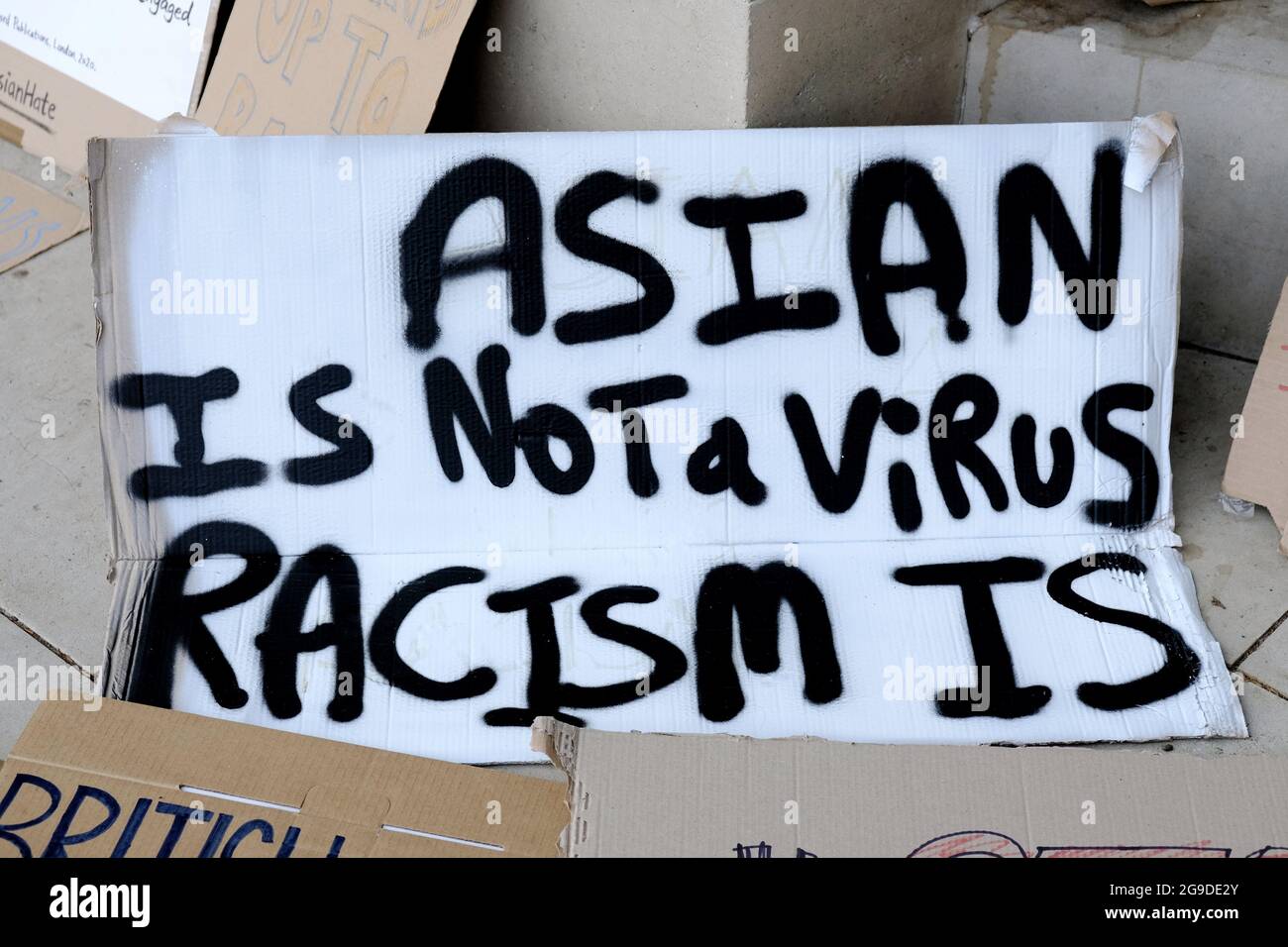Un cartello con le parole "l'Asia non è un virus, il razzismo è" in un raduno anti-razzismo, visto che il Regno Unito vede un aumento del 300 per cento del crimine di odio durante la pandemia. Foto Stock