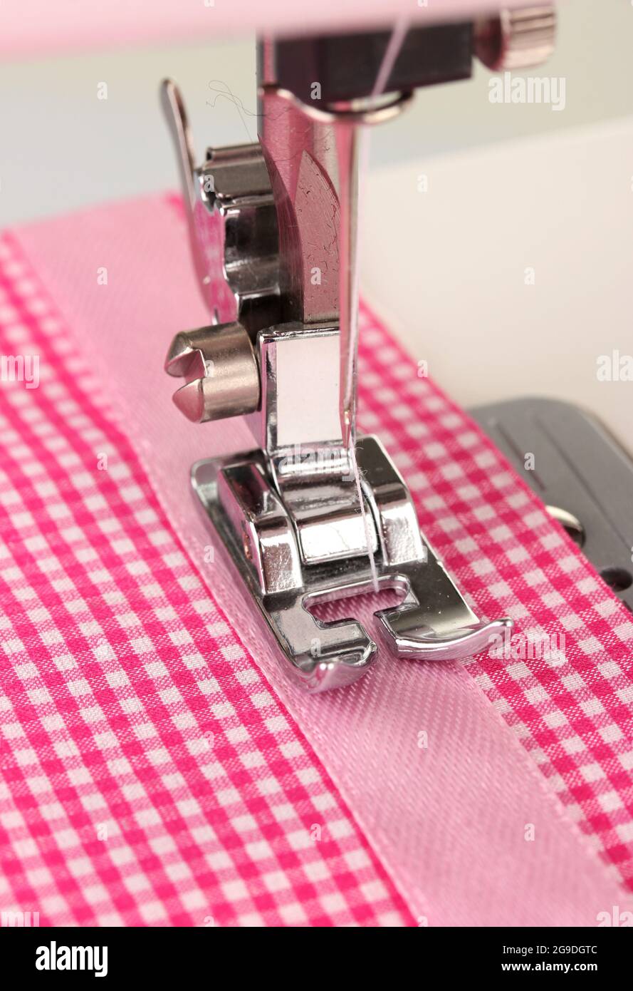 Primo piano della parte di lavoro della macchina da cucire con panno rosa  Foto stock - Alamy