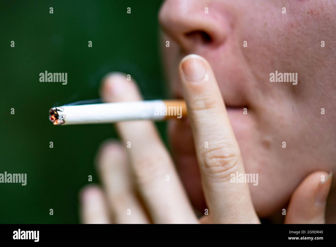 Berlino, Germania. 24 luglio 2021. Una donna prende un trascinamento su una sigaretta. I tossicodipendenti sono stati colpiti particolarmente duramente dalle restrizioni della Corona Lockdown nel corso dell'ultimo anno e mezzo. Credit: Fabian Sommer/dpa/Alamy Live News Foto Stock