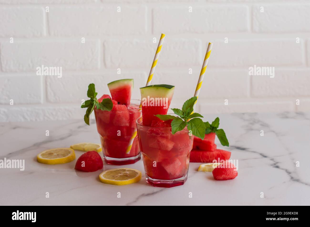 Succo di cocomero fresco con menta e ghiaccio nel bicchiere su sfondo di marmo. Dolce dessert estivo, cocktail concetto di cibo sano, estate. Selettivo Foto Stock