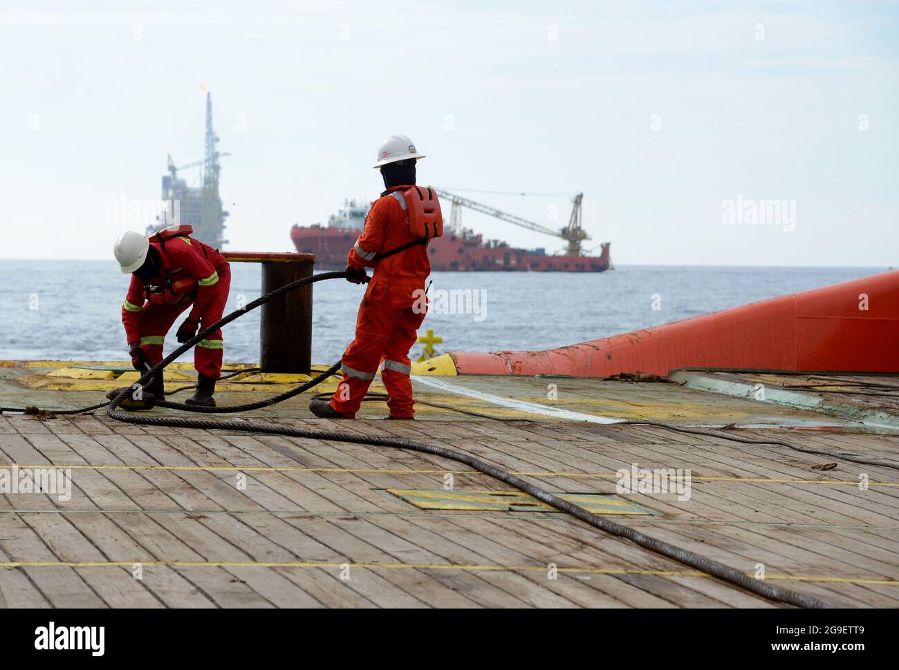 equipaggio marino che lavora sul ponte durante l'operazione di movimentazione dell'ancora in mare Foto Stock