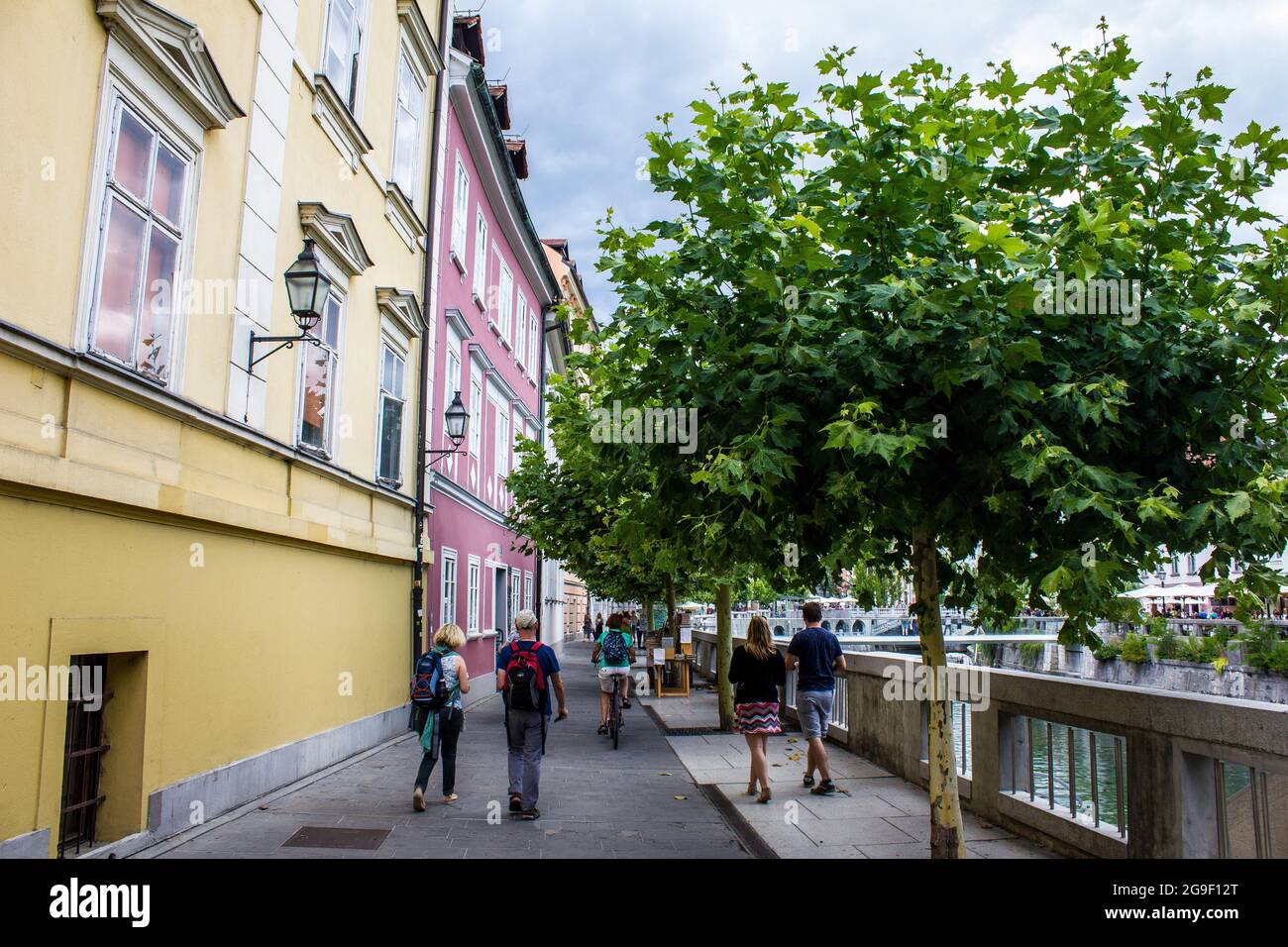 Lubiana, Slovenia - 15 luglio 2017: Vista delle persone a piedi lungo il fiume nel centro di Lubiana in una giornata di sole Foto Stock