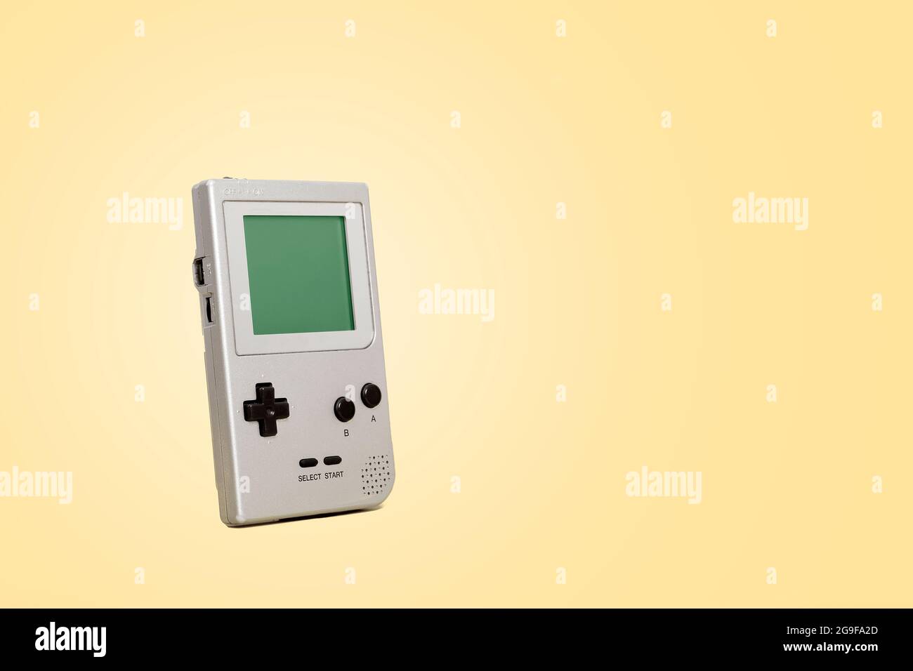 Console per giochi retrò portatile vintage su sfondo giallo vintage con spazio per la copia e spazio per il testo. Foto Stock