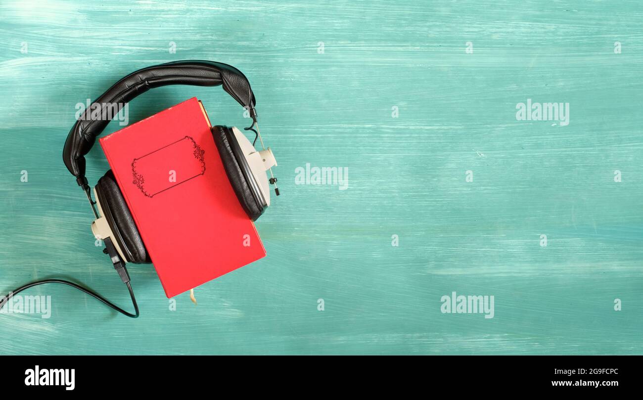 concetto di audiolibro con libro e cuffie vintage, letteratura, intrattenimento, istruzione, spazio di copia sulla copertina del libro Foto Stock