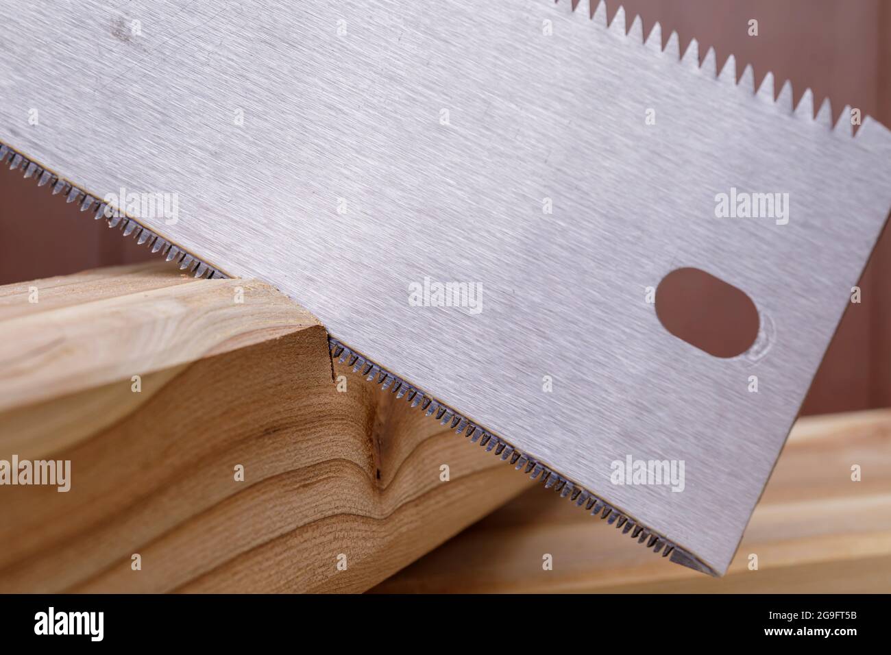 Sega a mano e tavole di legno. Sega con un dente giapponese. Legno di acero. Foto Stock