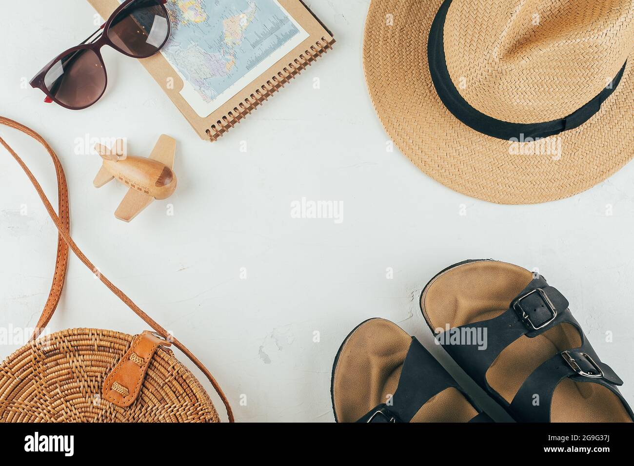 Spostamento in piano. Borsa in rattan, cappello di paglia, occhiali da  sole, sandali, taccuino con mappa, aereo. Vista dall'alto Foto stock - Alamy