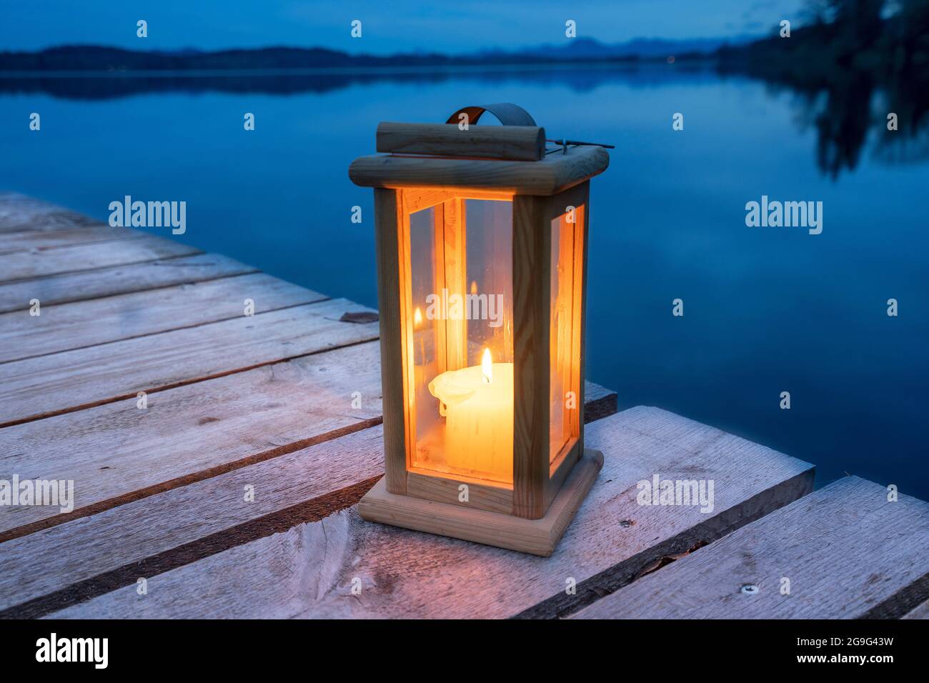 Una candela che brucia in una lanterna su un molo a Waginger See. Alta Baviera, Germania Foto Stock