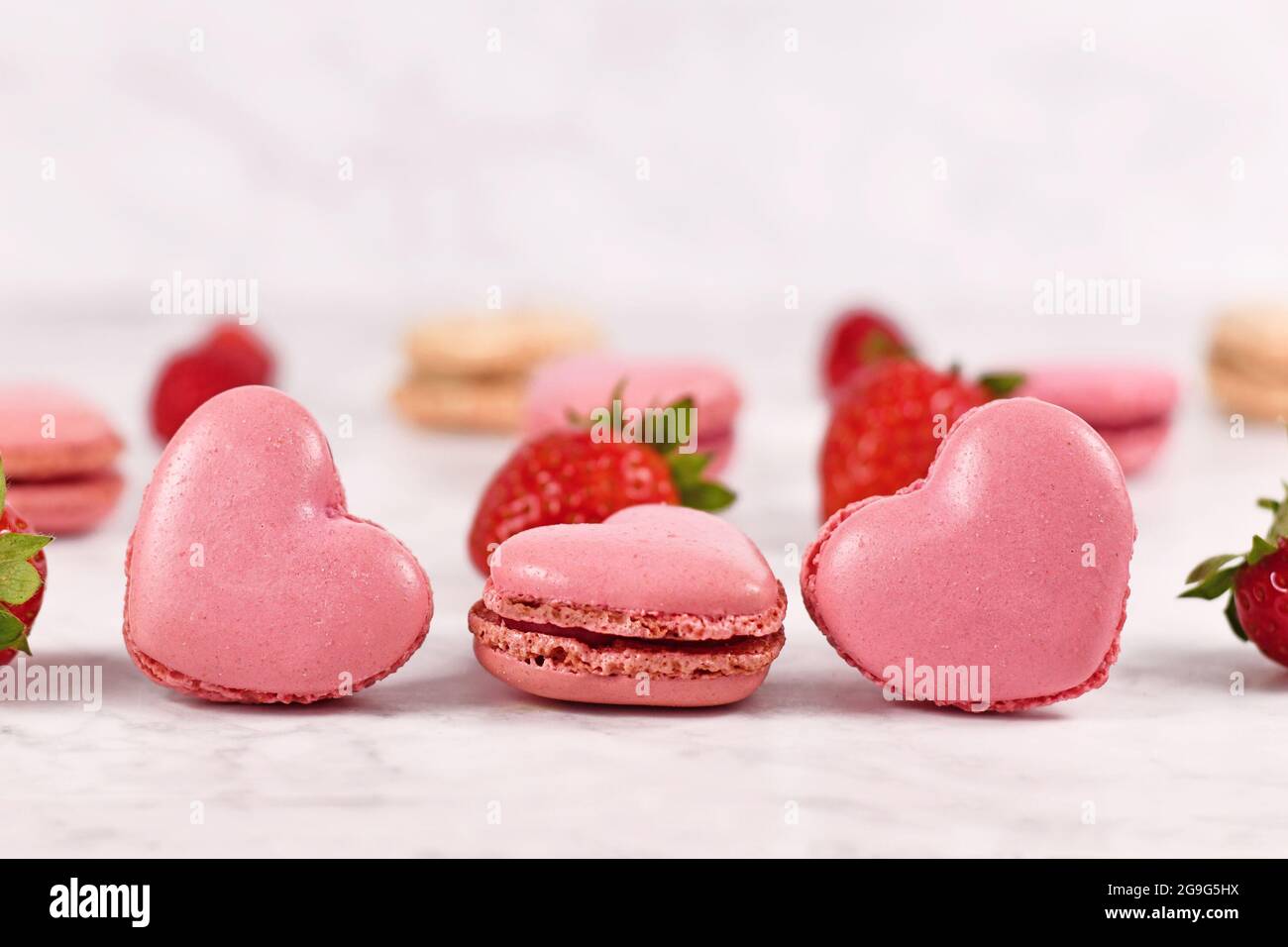 I dolci di macaron francesi a forma di cuore rosa dal sapore fragoroso Foto Stock