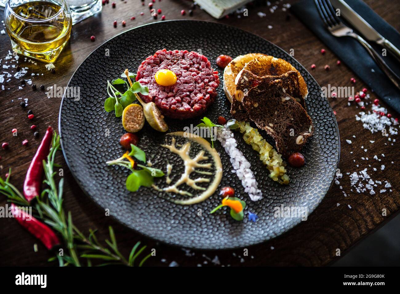Tartare di manzo da Black Angus. Cipolla, uova di quaglia, salsa di pomodoro, maionese di senape. Delizioso e salutare primo piano di cucina italiana tradizionale servito per pranzo Foto Stock