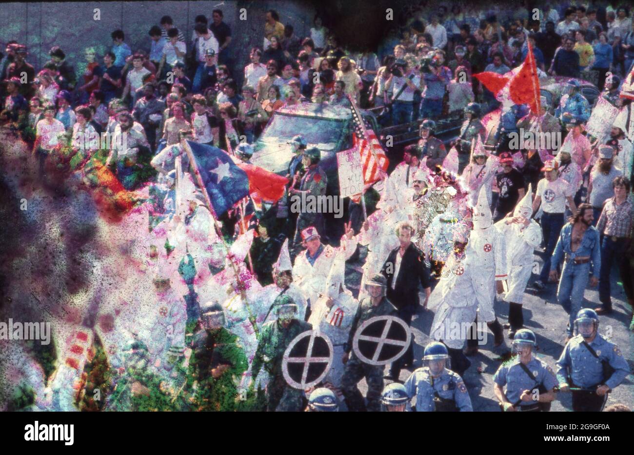 Austin, Texas USA, circa 1983: Un piccolo gruppo di membri del Ku Klux Klan, affiancati dalla polizia, sfilano attraverso il centro di Austin, dove vengono incontrati da una folla ostile anti-KKK. ©Bob Daemmrich Foto Stock