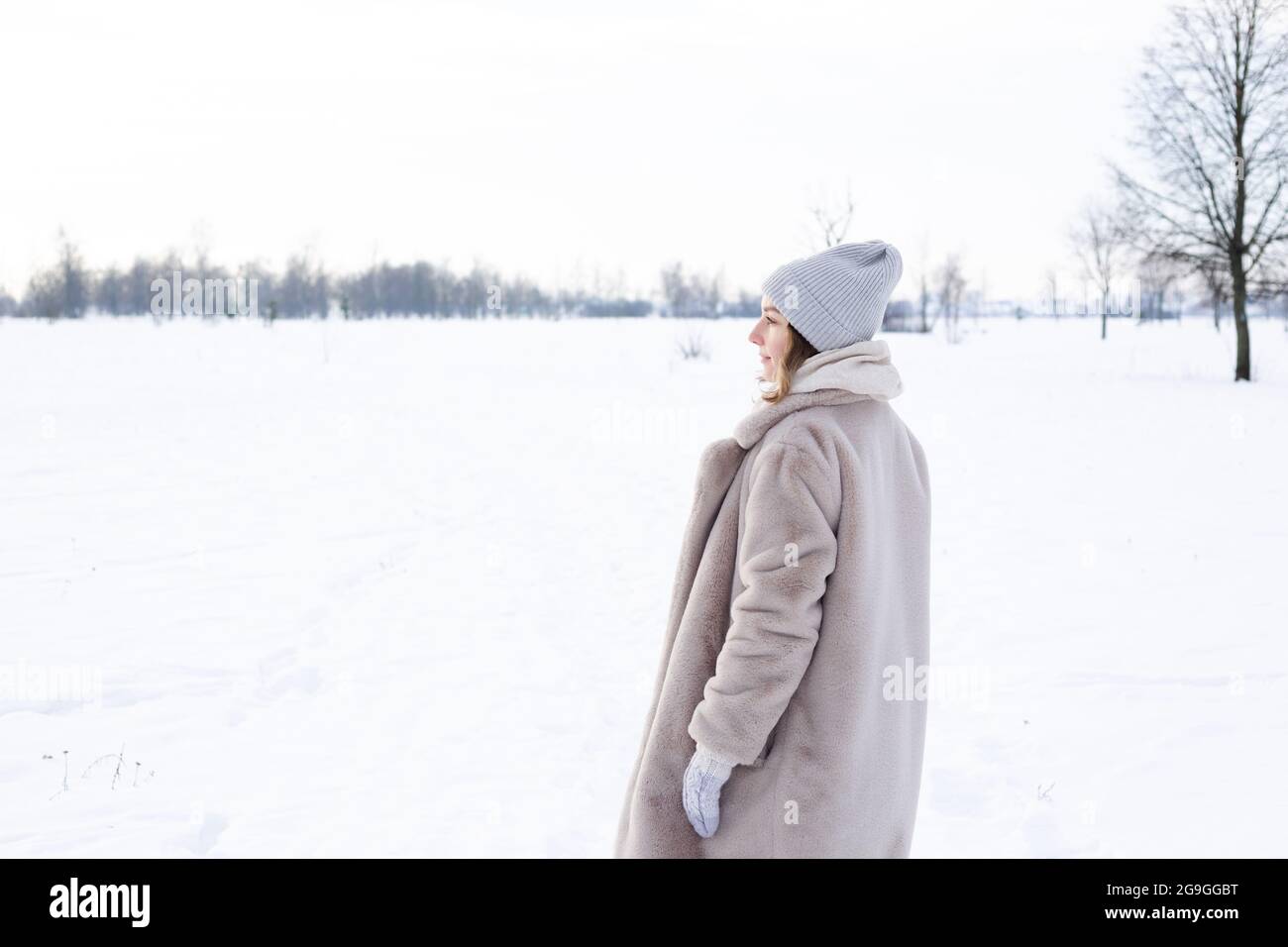 Giovane ragazza in abiti beige, cappotto di pelliccia artificiale passeggiate in inverno Foto Stock