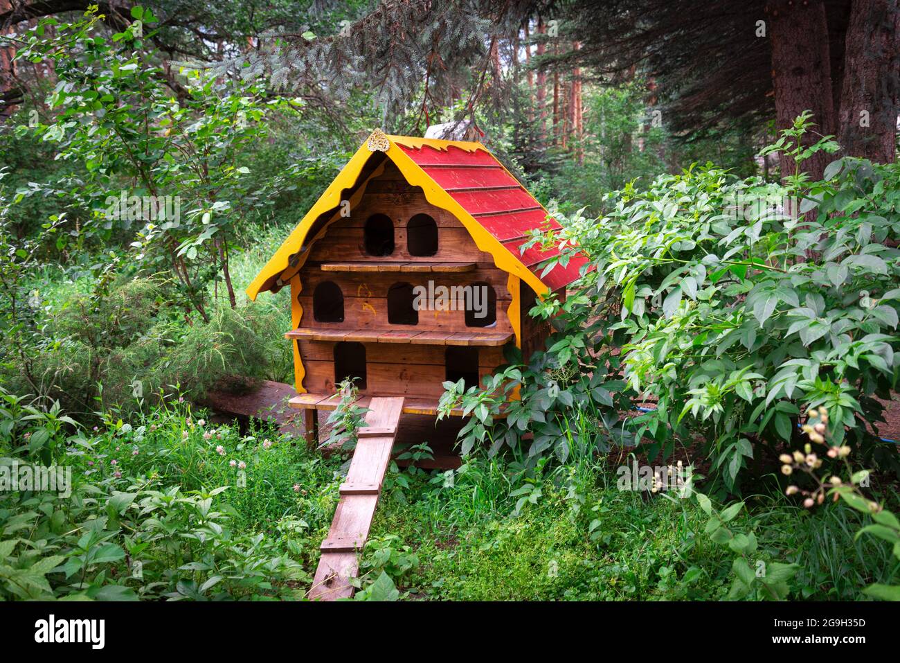 una casa di legno per i gatti senza casa si trova nel parco tra gli alberi Foto Stock