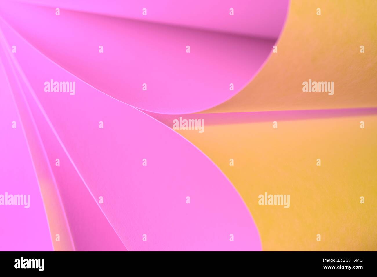 Bella immagine creativa di carta bianca comune scorre rosa e giallo colorato con l'uso di flash luce colorata Foto Stock
