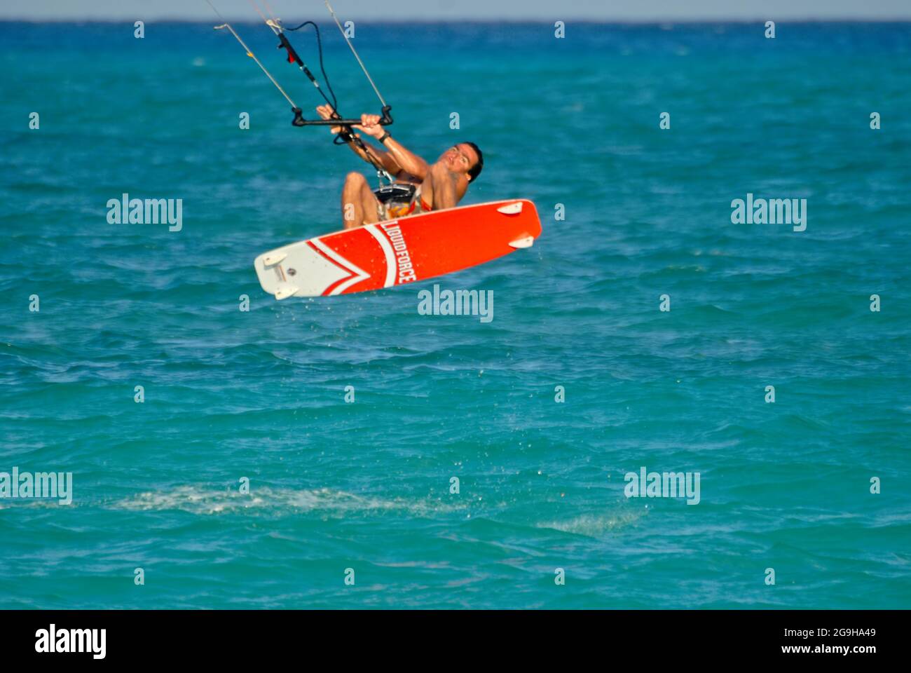 Primo piano di un giovane Kitesurfer che sorvola il Mar dei Caraibi vicino a una spiaggia tropicale in Messico Foto Stock