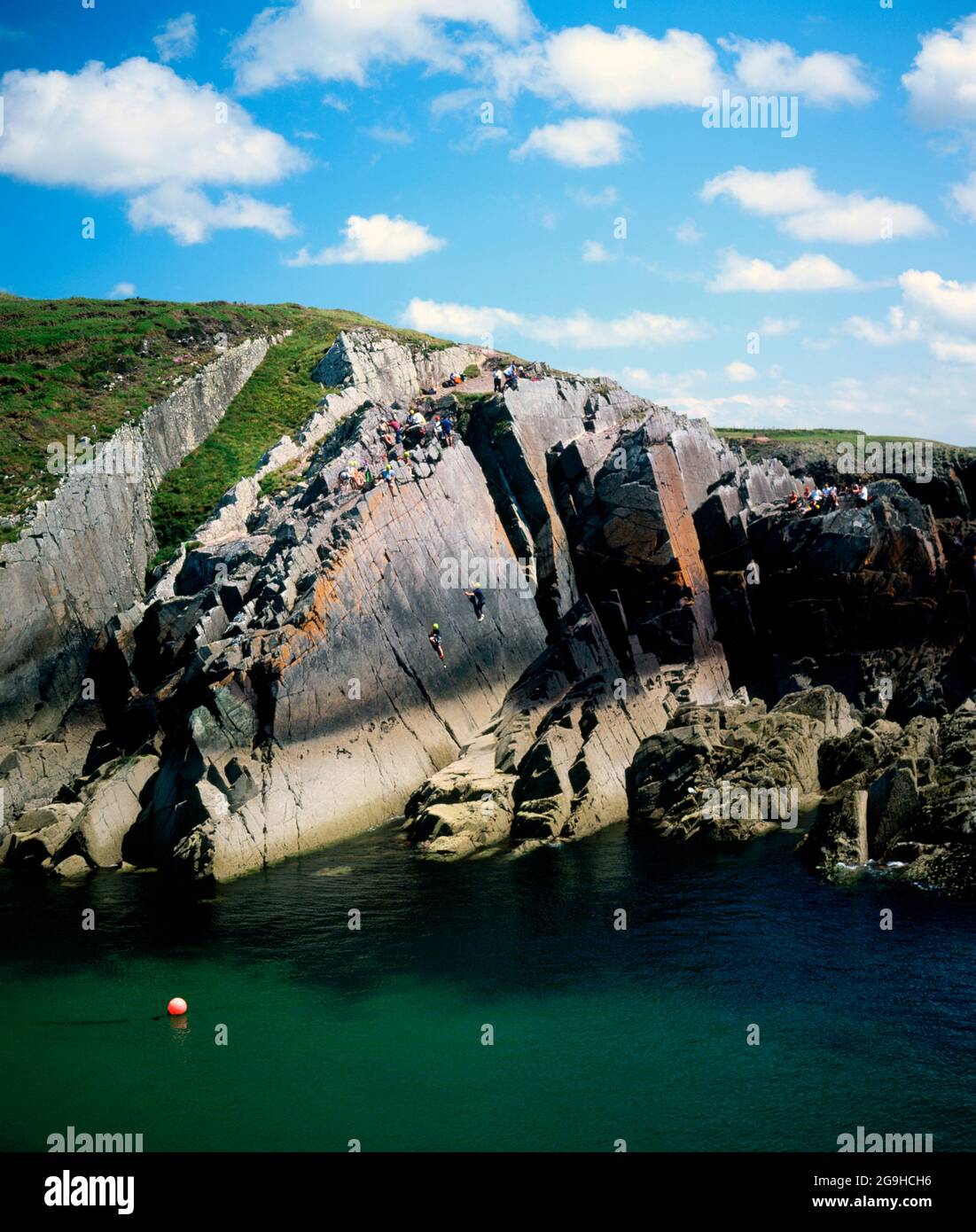 scalatori di roccia su rockface, porthclais, st davids, pembrokeshire, galles occidentale. Foto Stock
