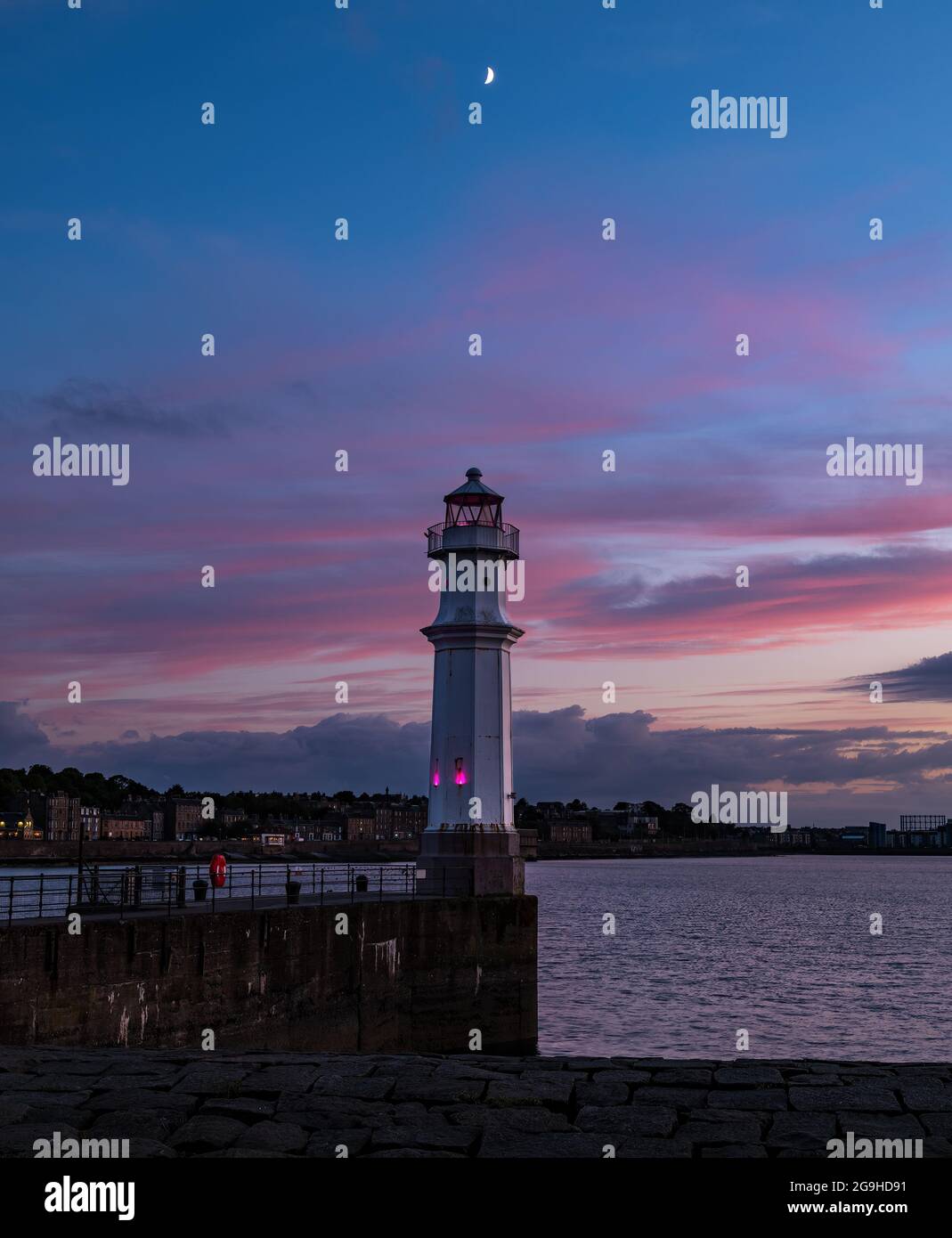 Faro del porto di Newhaven con luna crescente nel colorato cielo notturno rosa, Edimburgo, Scozia, Regno Unito Foto Stock