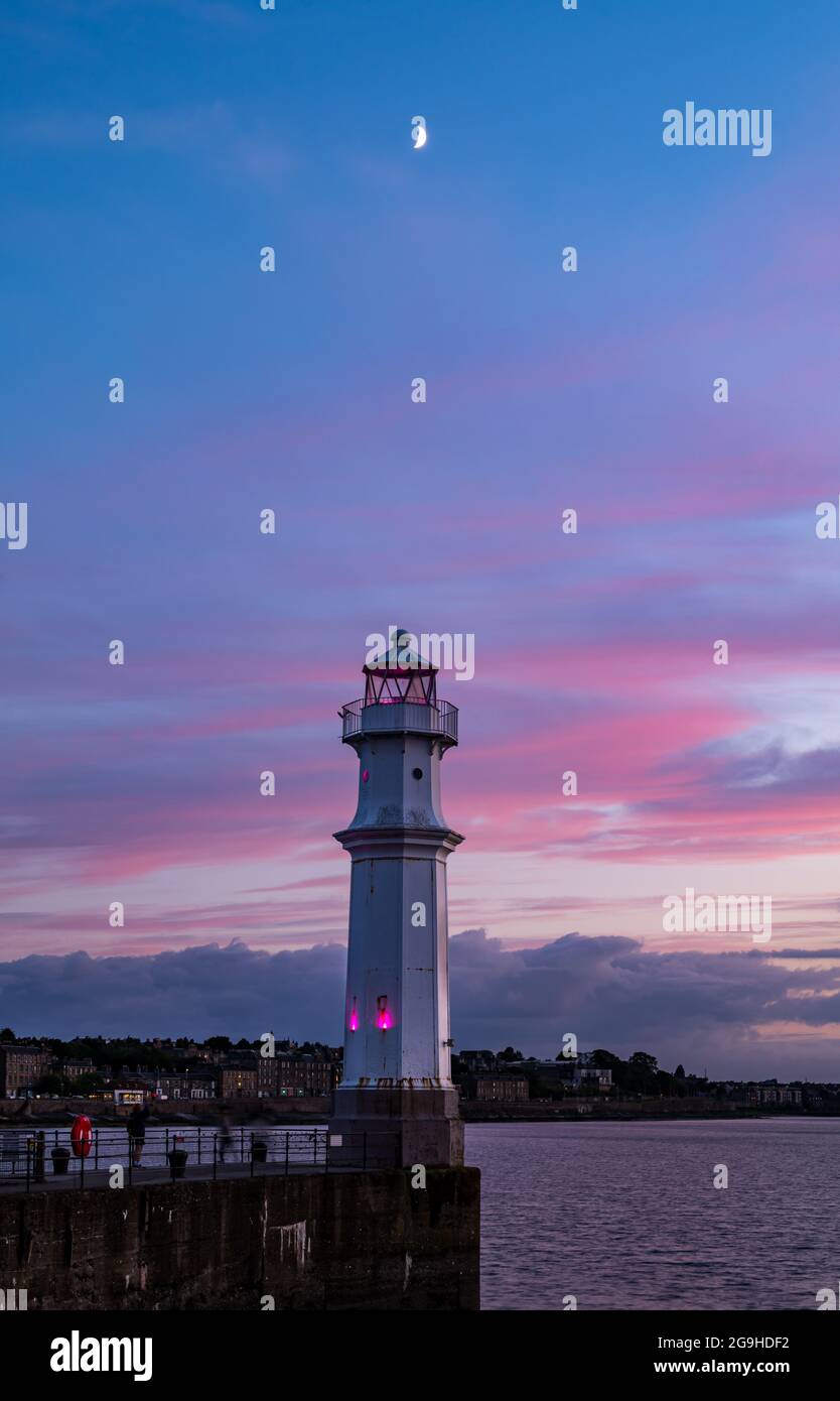 Faro del porto di Newhaven con luna crescente nel colorato cielo notturno rosa, Edimburgo, Scozia, Regno Unito Foto Stock