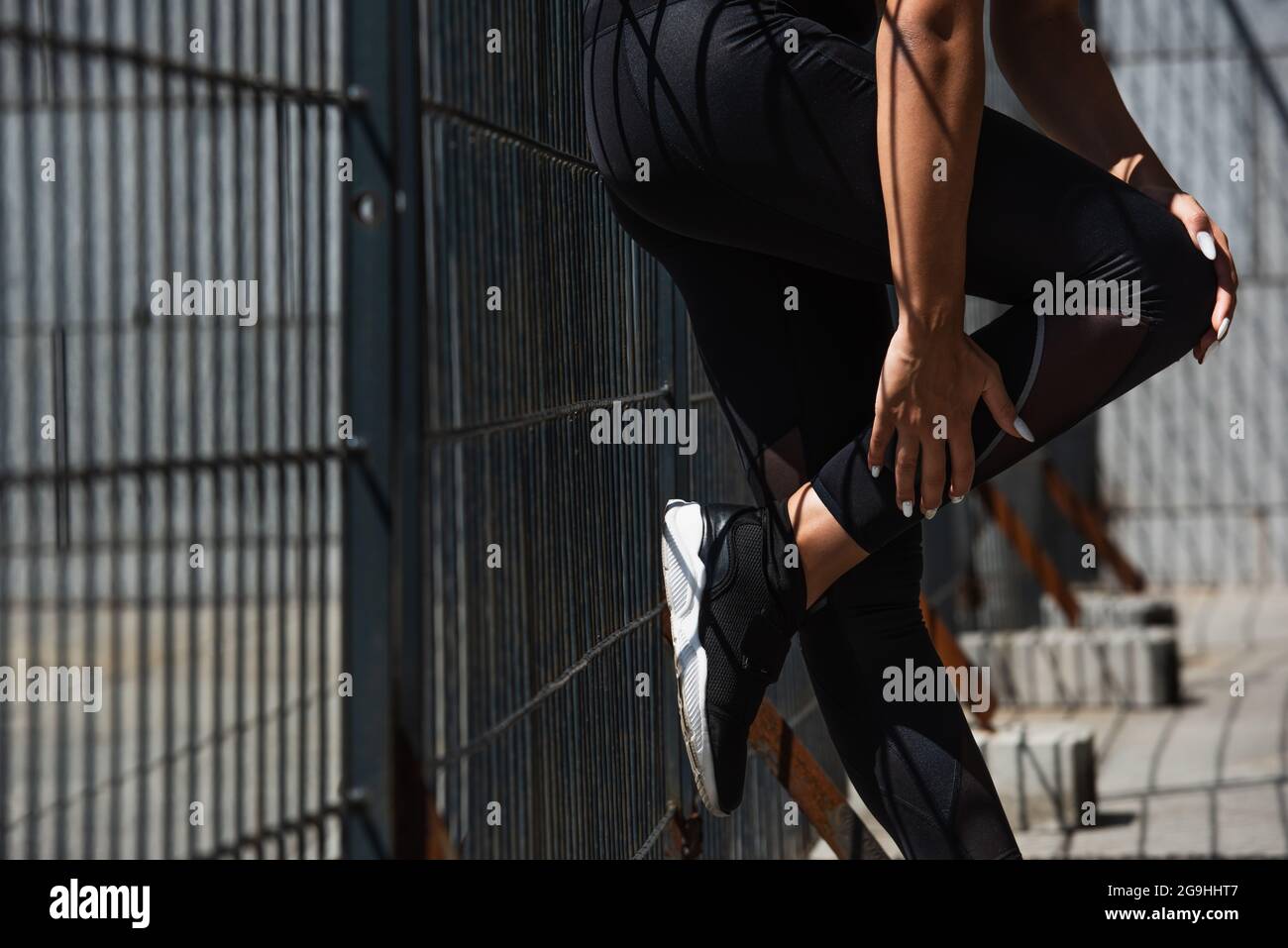 Vista ritagliata della sportiva afroamericana in piedi vicino recinzione Foto Stock