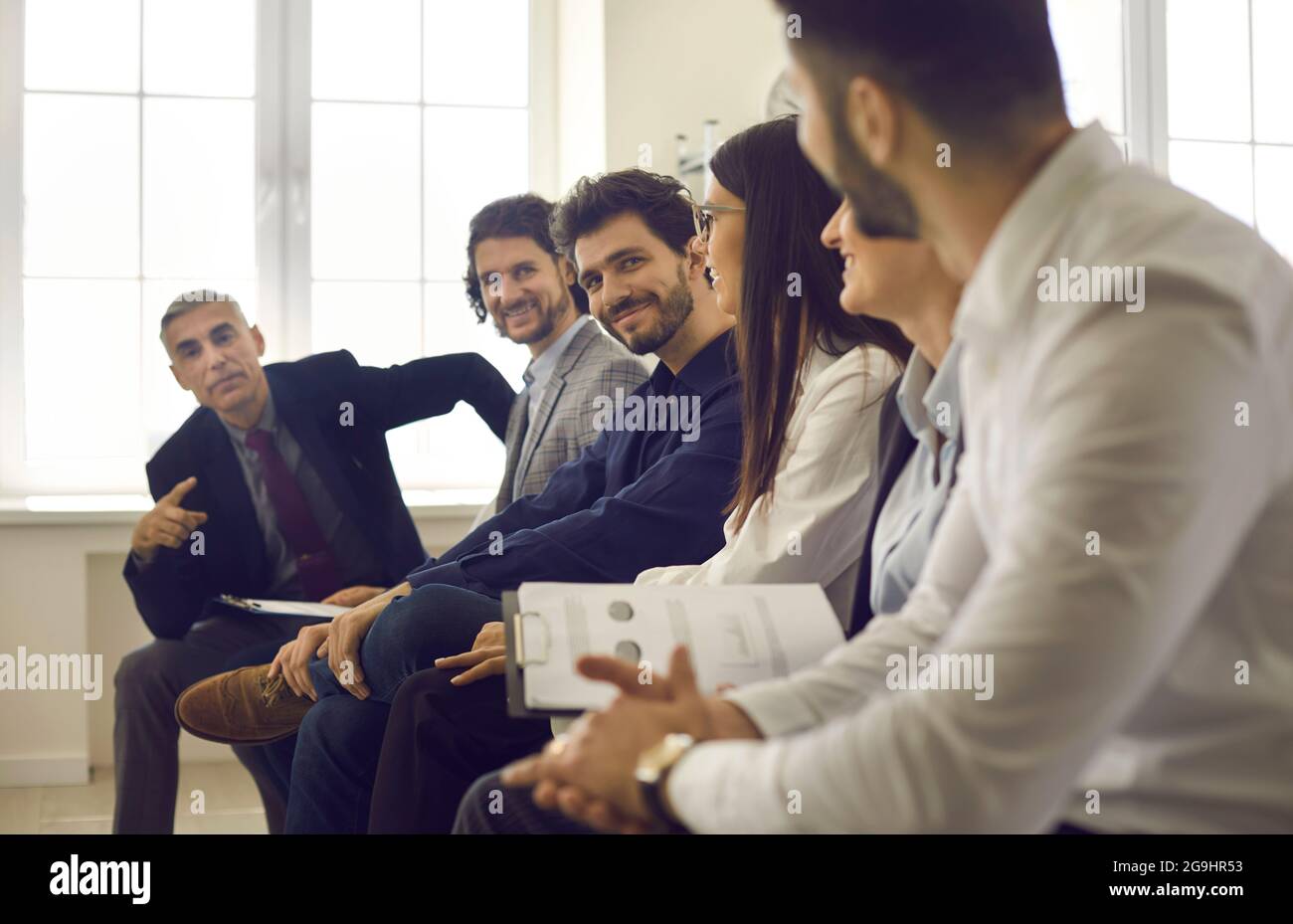 Gruppo di persone che hanno una discussione durante la riunione o la presentazione in ufficio Foto Stock