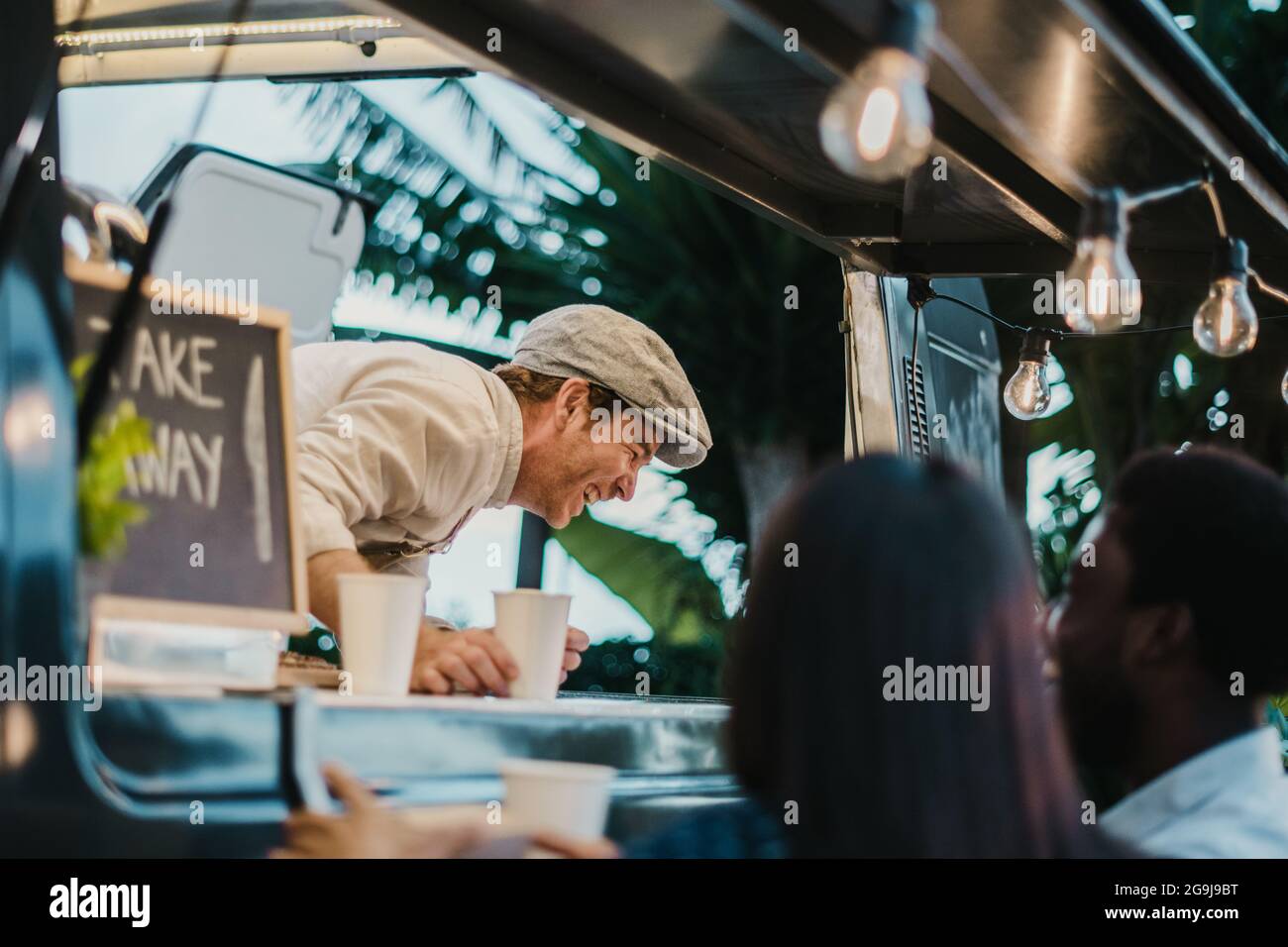 Venditore di camion del cibo ridendo a scherzo dei clienti Foto Stock