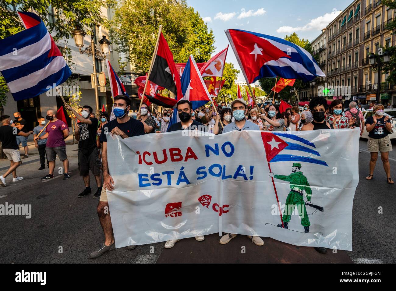 Madrid, Spagna. 26 luglio 2021. Manifestanti con bandiere e cartelli durante una manifestazione contro l’embargo economico statunitense su Cuba, in coincidenza con il 26 luglio, giorno in cui la rivoluzione cubana è iniziata nel 1953, 68 anni fa. Il cartello recita: 'Cuba non sei solo' Credit: Marcos del Mazo/Alamy Live News Foto Stock