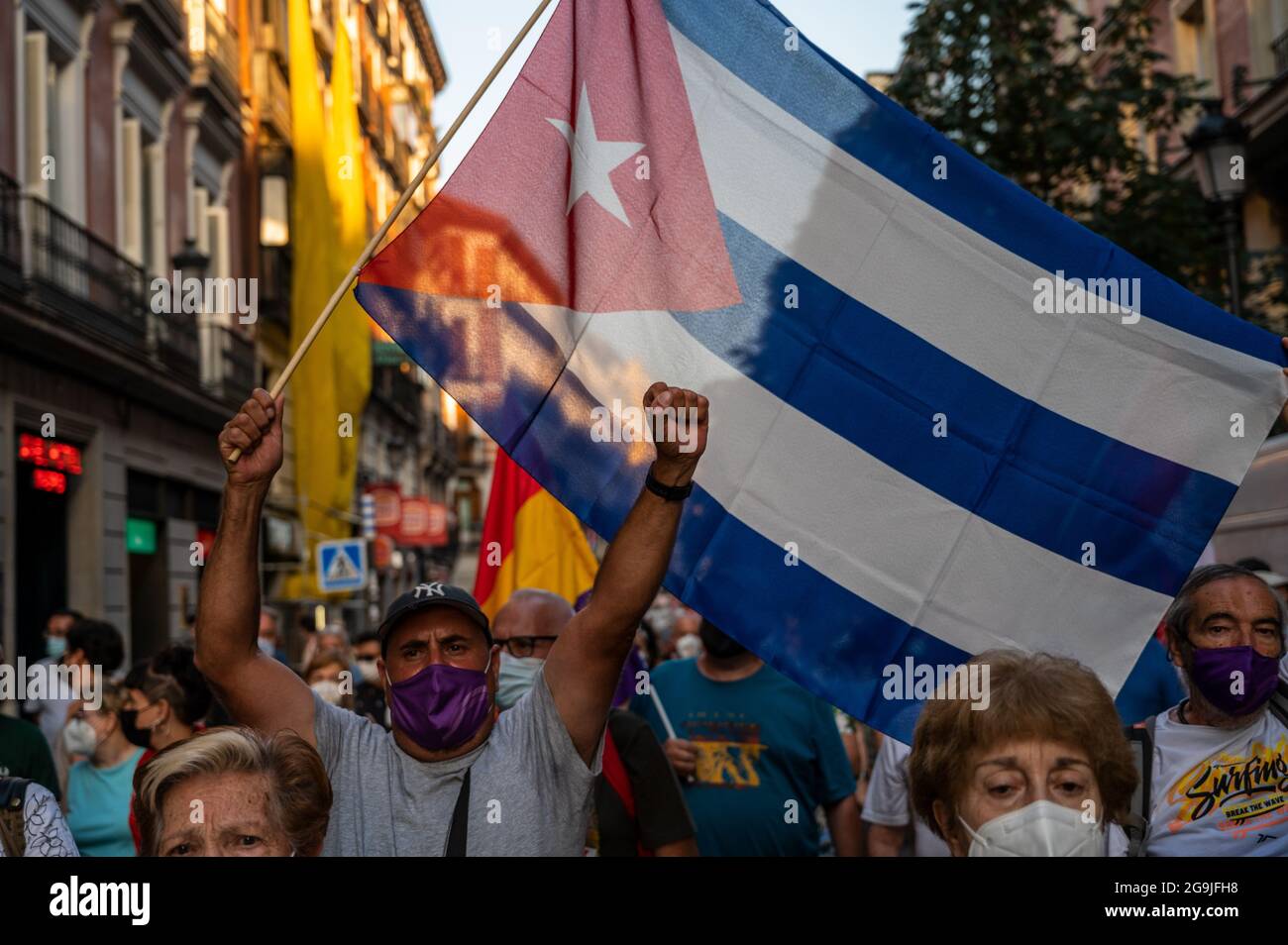 Madrid, Spagna. 26 luglio 2021. Un manifestante che porta una bandiera cubana che alza la mano durante una manifestazione contro l'embargo economico statunitense su Cuba, in coincidenza con il 26 luglio, il giorno in cui la rivoluzione cubana è iniziata nel 1953, 68 anni fa. Credit: Marcos del Mazo/Alamy Live News Foto Stock