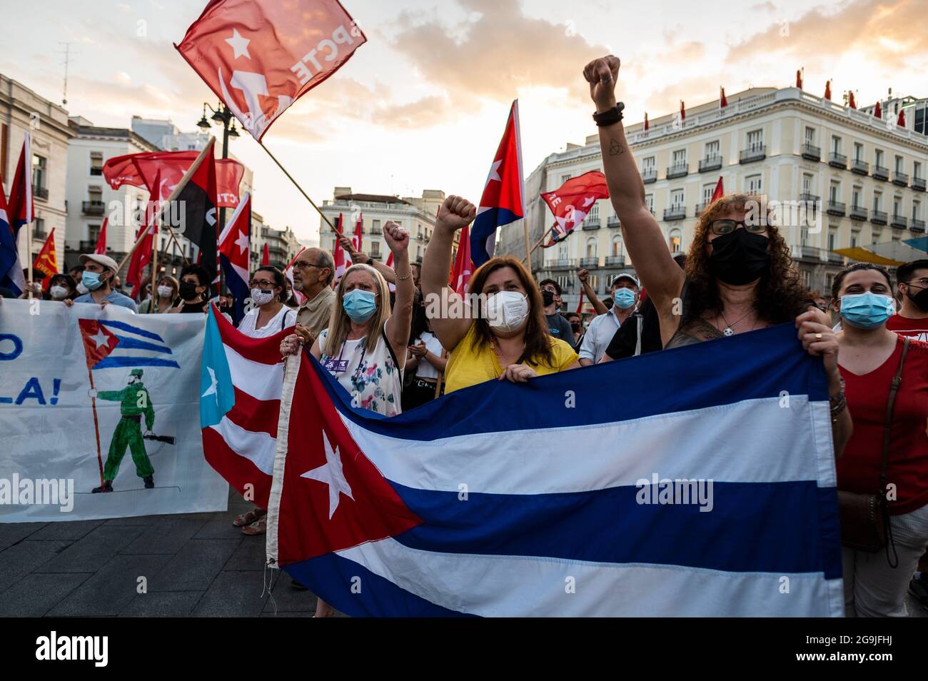 Madrid, Spagna. 26 luglio 2021. Manifestanti con bandiere cubane che alzano le armi durante una manifestazione contro l’embargo economico statunitense su Cuba, in coincidenza con il 26 luglio, giorno in cui la rivoluzione cubana è iniziata nel 1953, 68 anni fa. Credit: Marcos del Mazo/Alamy Live News Foto Stock