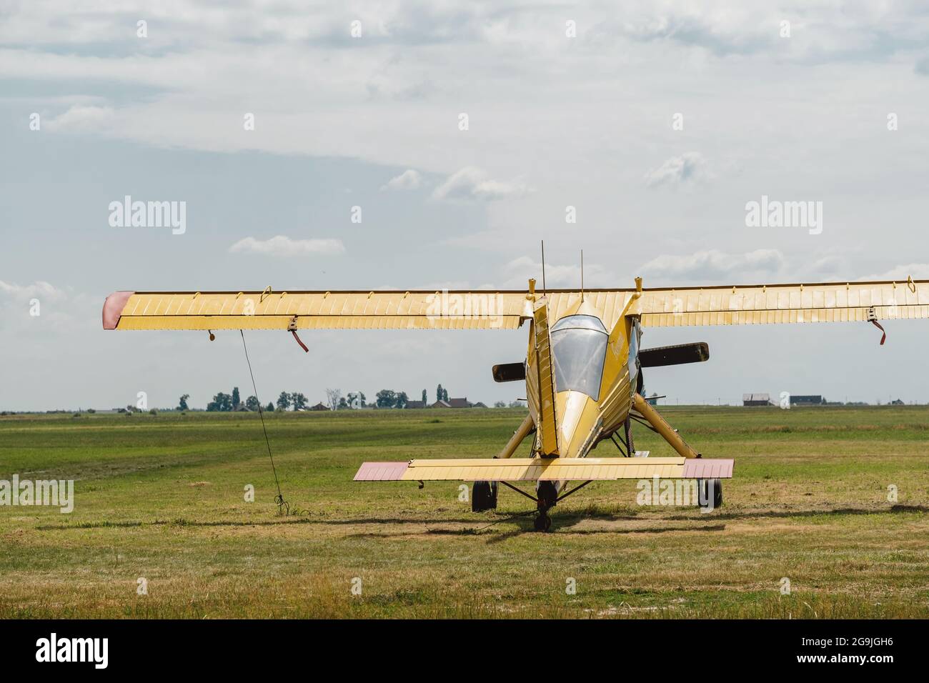 Aereo giallo vintage sul campo d'aviazione in attesa di entrare nella vista aerea dal retro. Velivolo leggero ad ala alta, monomotore, convenzionalmente disposto Foto Stock