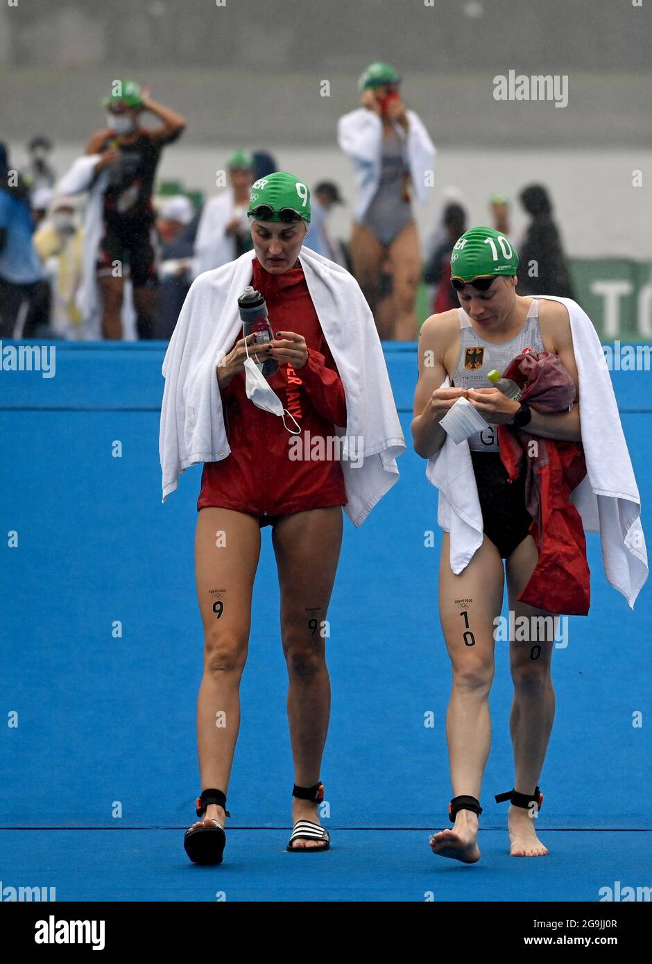 Tokyo, Japan. 27th July, 2021. Triathlon: Olympics, Olympic distance (1.5km swim, 40km bike, 10km run), women at Odaiba Marine Park. Anabel Knoll (l) of Germany and Laura Lindemann of Germany walk the course in the rain before the start. Credit: Sebastian Gollnow/dpa/Alamy Live News Foto Stock