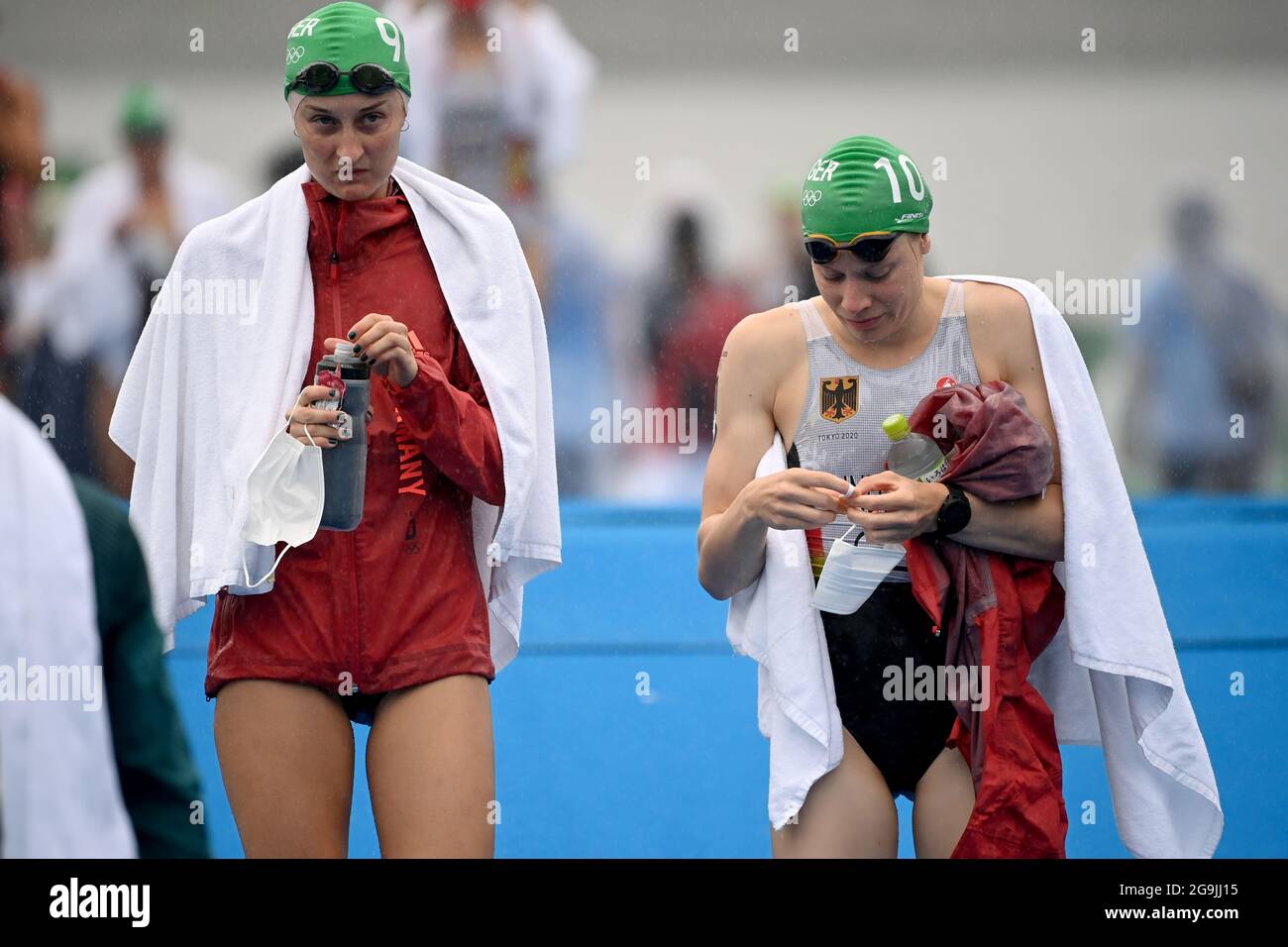 Tokyo, Japan. 27th July, 2021. Triathlon: Olympics, Olympic distance (1.5km swim, 40km bike, 10km run), women at Odaiba Marine Park. Anabel Knoll (l) of Germany and Laura Lindemann of Germany walk the course in the rain before the start. Credit: Sebastian Gollnow/dpa/Alamy Live News Foto Stock
