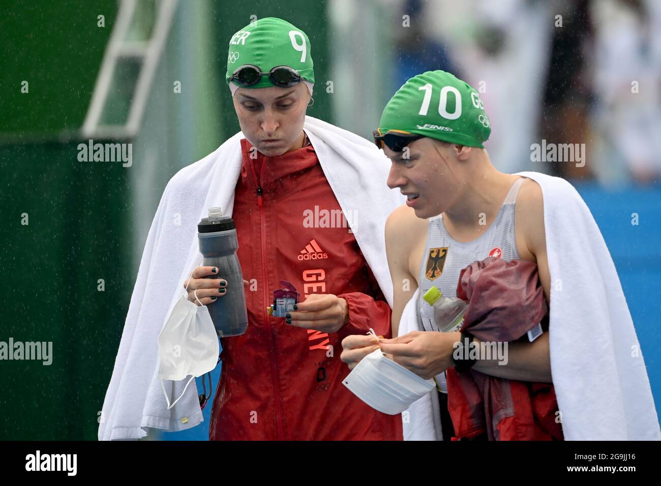 Tokyo, Japan. 27th July, 2021. Triathlon: Olympics, Olympic distance (1.5km swim, 40km bike, 10km run), women at Odaiba Marine Park. Anabel Knoll (l) of Germany and Laura Lindemann of Germany walk the course in the rain before the start. Credit: Sebastian Gollnow/dpa/Alamy Live News Foto Stock