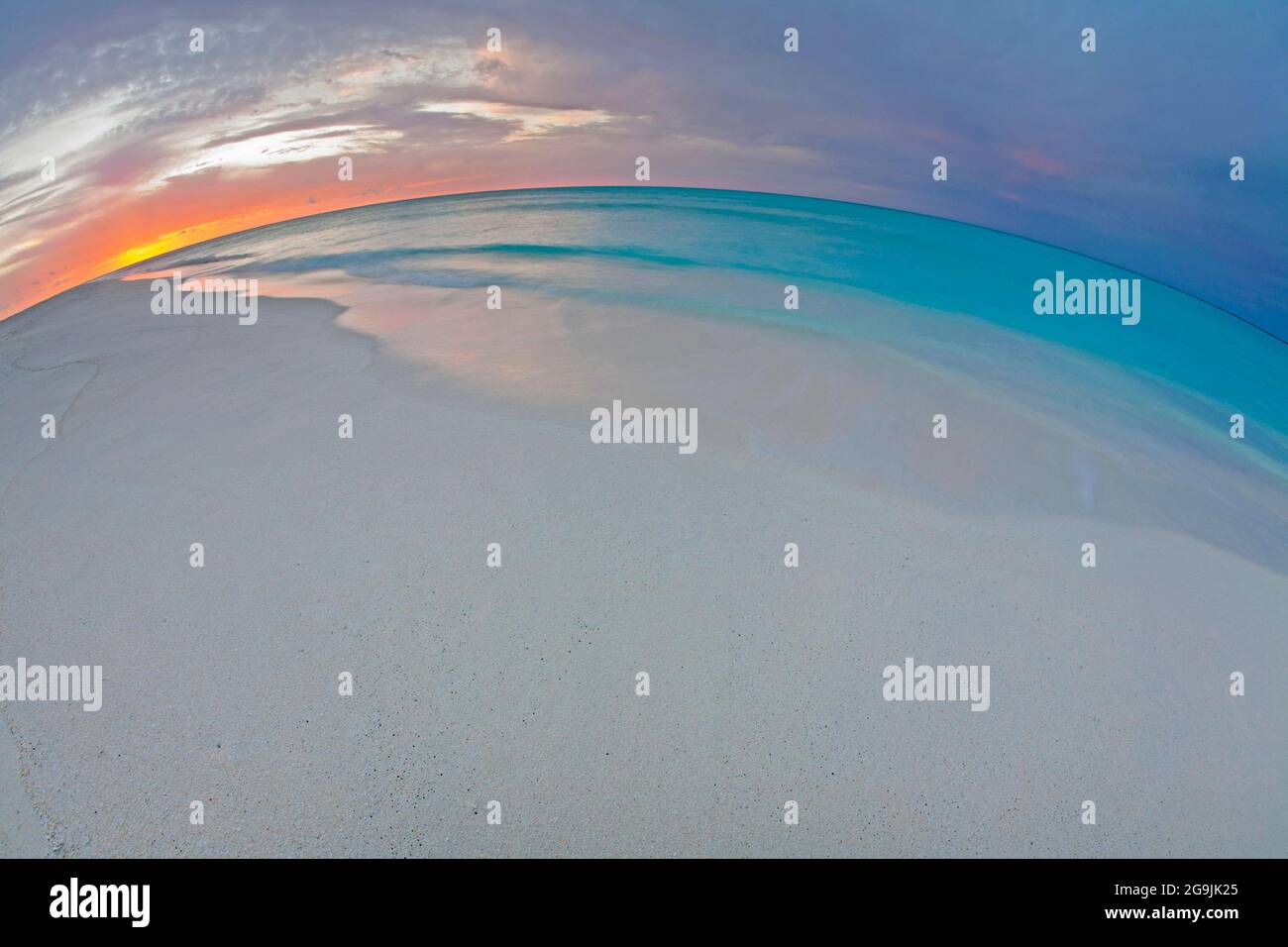 Cielo al tramonto sulla spiaggia dell'atollo Midway e sulla laguna sull'isola di sabbia nel monumento nazionale marino di Papahanaumokuakea, con orizzonte curvo Foto Stock